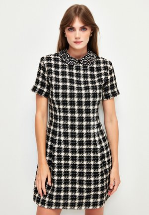 Kurzärmliges schwarz-weiß karierter Kleid mit Kragen und Perlen. Hergestellt aus strukturiertem Stoff, tailliertem Schnitt, knielanger Gestaltung.