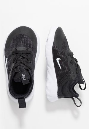 Czarno-białe buty sportowe Nike z dzianinową teksturą, wiązane sznurówki i pętelki do łatwego zakładania, pokazane z góry i z boku na białym tle.