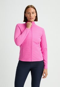 Rosa zip-up-jacka med en texturerad yta, hög krage och långa ärmar. Har två sidfickor och en figursydd design.