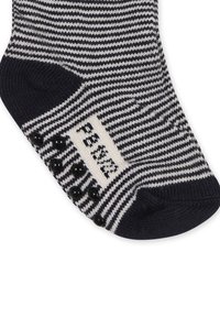 Skarpetki w niebiesko-białe paski z fakturowanym wzorem, czarnymi silikonowymi punktami antypoślizgowymi na spodzie oraz białą metką z czarnym napisem po boku.