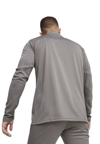 Graues, athletisches Langarmshirt mit strukturiertem Design an den Schultern, eng anliegendem Ärmel und rundem Ausschnitt. Glattes, leichtes Material.