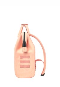 Peach-colored backpack with a cylindrical shape, quilted texture, black zipper, and three horizontal straps on the front.