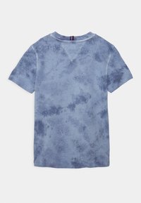 Camiseta de manga corta azul tie-dye con cuello redondo, que presenta una tela texturizada con tonos diversos y sutiles detalles de patrón.