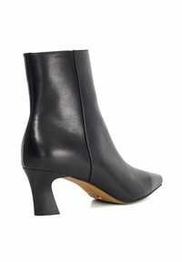 Bottines noires en cuir avec un bout pointu et un talon aigu. Texture lisse et détails de couture sur les côtés.