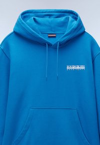 Blauwe hoodie gemaakt van zacht materiaal. Beschikt over een voorzak en een wit logo op de borst. Klassiek ontwerp met verstelbare koordjes.