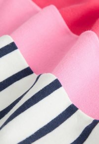 Rózsaszín és fehér árnyalatú pamutszövet, tengerészkék csíkokkal. Puha tapintású, rétegezett szövetredőkkel.