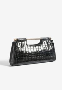 Bolso de mano de piel sintética negra con textura de cocodrilo, con un asa de metal dorado y una forma estructurada.
