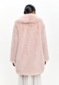 Rosa faux fur frakke med bred krave, lange ærmer og en blød, fluffy tekstur, med et knælangt design og afrundet kant.