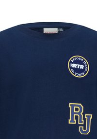 Granatowa koszulka T-shirt z bawełny, okrągłym dekoltem. Na przodzie znajduje się okrągła naszywka z logo oraz haftowane "RJ" w kolorze żółtym.