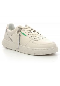 Zapatillas de cuero blanco con un acabado texturizado, que cuentan con un acento verde y una etiqueta de metal. Suela gruesa y diseño clásico de cordones.
