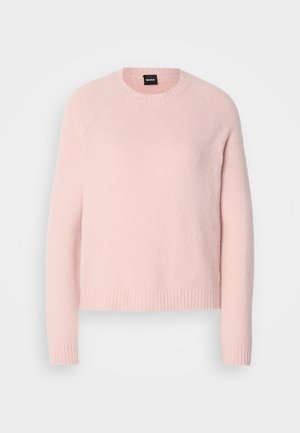 Lys rosa, myk ullgenser med rund hals, ribbede mansjetter og kant. Har et enkelt design uten mønstre eller pynt.