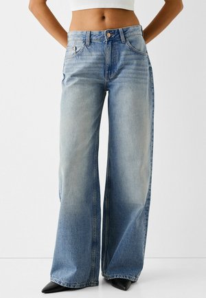 Light blue wide-leg jeans made of denim, featuring a high waist, two front pockets, and a button closure. Distressed finish with fading.
