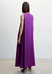 Robe maxi violette sans manches en tissu léger, avec un détail en forme d'ouverture au dos et une silhouette fluide. Design simple et élégant.