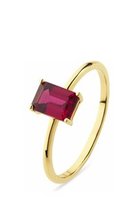 Goldfarbener Ring mit einem rechteckigen facettierten roten Edelstein, der in vier Krappen auf einem dünnen, glatten Band mit polierter Oberfläche gefasst ist.