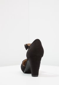 Czarne zamszowe szpilki z zaokrąglonym czubkiem, paskiem wokół kostki i teksturowanym obcasem. Podeszwa jest czarna o gładkim wykończeniu.