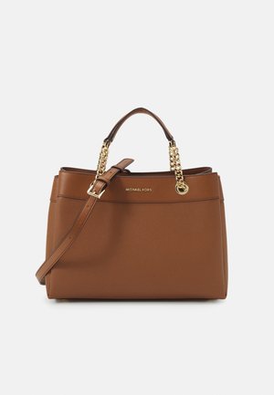 Sac fourre-tout synthétique marron avec deux poignées supérieures et une bandoulière amovible. Présente des accents en chaîne dorée et une plaque avec logo.