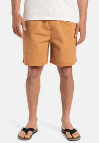 Pantalones cortos de un tejido naranja-marr�ón cálido, con un corte recto y dobladillo cosido. Combinados con chanclas negras. Diseño minimalista.