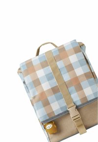 Checked pattern backpack in light blue, beige, and white; fabric includes a small bear-shaped zipper pull and a beige strap closure.