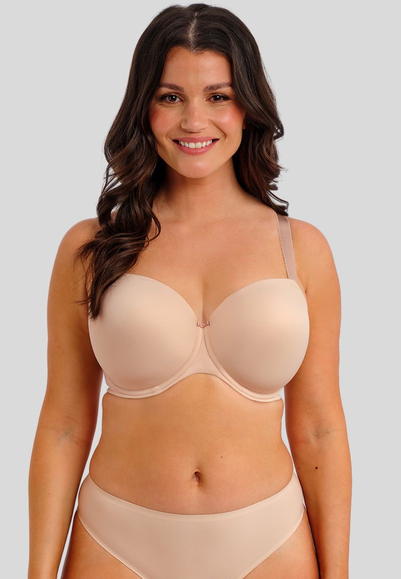 Světle béžová vycpaná podprsenka s kosticemi, nastavitelnými ramínky a hladkým povrchem. Vytvořeno v kombinaci s odpovídajícími vysokými kalhotkami.