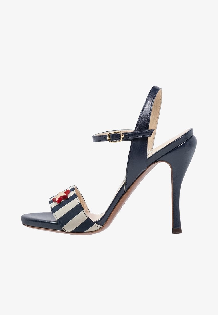 Sandale à talons hauts bleu marine avec une finition brillante, dotée d'une bande en tissu rayée et d'un accent en étoile rouge. Bride à la cheville réglable pour un ajustement parfait.