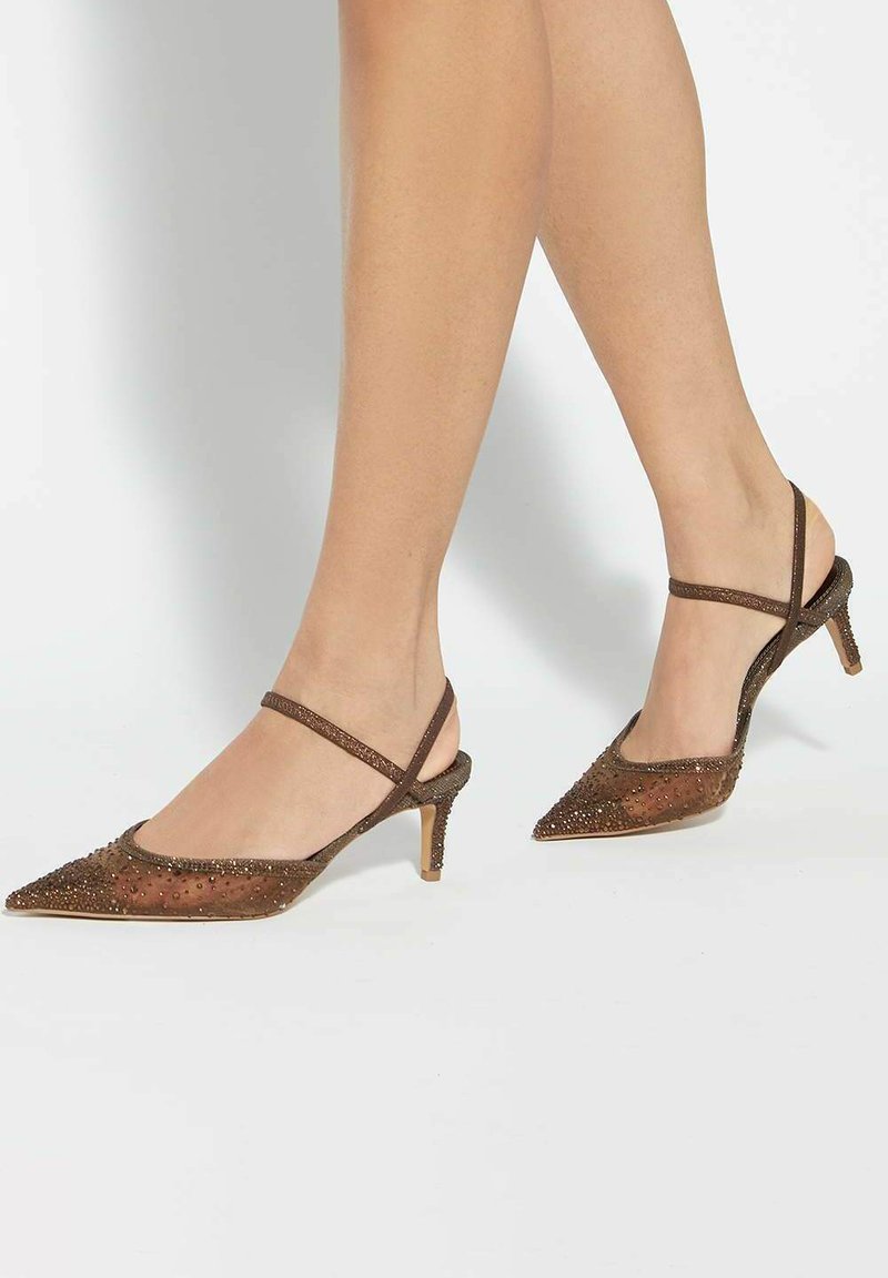 Brown slingback heels with a pointed toe. Features embellishments and a textured surface. Slightly raised heel with a thin ankle strap.