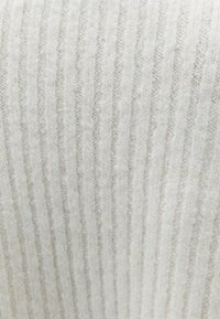 Lichtgrijs ribbelstof met een zachte, harige textuur, voorzien van verticale strepen. Het materiaal is pluizig en warm, geschikt voor comfortabele kleding.