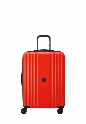 Valigia rigida rossa con scanalature verticali, dettagli neri, maniglia retrattile e quattro ruote per una facile mobilità.