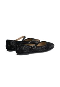 Zapatos planos negros con un diseño tejido texturizado, que cuentan con una correa con una hebilla de metal. La suela es plana y el interior está forrado.
