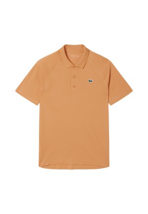 Polo de manga corta de color naranja con cuello, tres botones y pequeño logotipo de cocodrilo verde en el lado izquierdo del pecho.