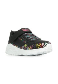 Schwarzer Sportschuh mit Klettverschluss, verziert mit mehrfarbigen Herzmustern und einer weißen, strukturierten Sohle.