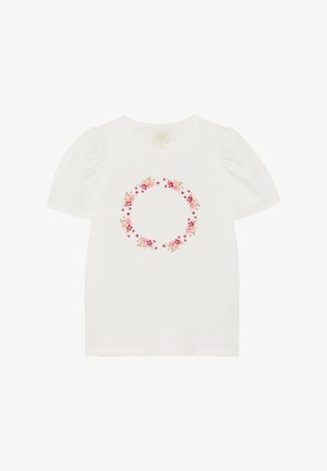 T-shirt en coton blanc avec manches courtes bouffantes et un motif de couronne florale en rose et beige au centre. Texture lisse.
