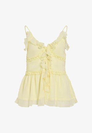 Blusa sin mangas de color amarillo claro con bordes con volantes, cierre con lazo delantero y dobladillo fluido y en capas.