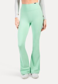 Leggings verde menta a zampa d'elefante realizzati in tessuto morbido e elasticizzato, con vita alta e dettagli laterali discreti.