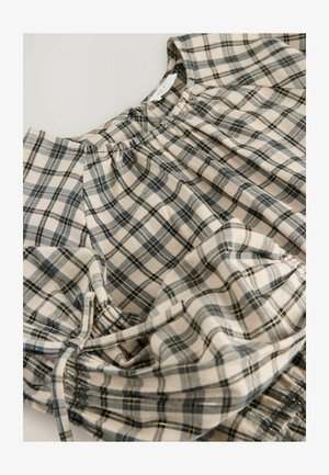 Tivă în carouri bej și albastru, cu detalii plisate și bandă elastică. Material din bumbac, cu o textură moale. Prezintă linii geometrice.