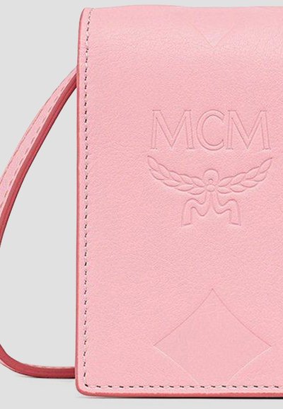 Μικρό ροζ δερμάτινο πορτοφόλι με ραμμένες άκρες, λουράκι καρπού και ανάγλυφο λογότυπο MCM με φτερά και γεωμετρικό σχέδιο.