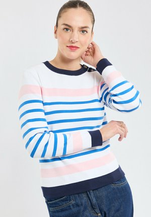 Pull en tricot rayé blanc, rose et bleu, avec un col et des poignets côtelés marine. Présente des accents de boutons sur l'épaule.