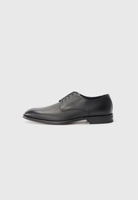Zapato de vestir para hombre de cuero negro con cordones, tacón bajo y acabado liso, ligeramente texturizado sobre fondo blanco plano.