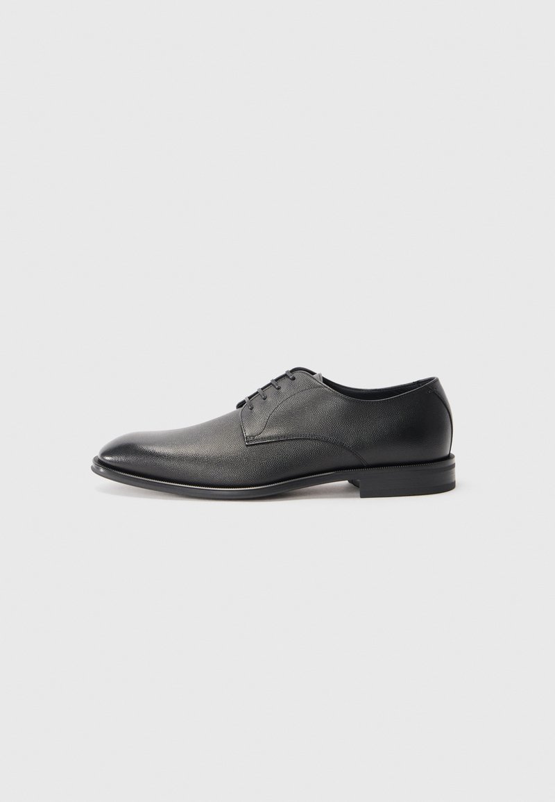 Zapato de vestir para hombre de cuero negro con cordones, tacón bajo y acabado liso, ligeramente texturizado sobre fondo blanco plano.