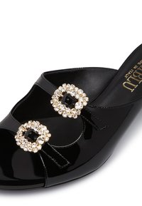 Black patent leather slide sandal featuring two jeweled square buckles, with a smooth texture and open-toe design.