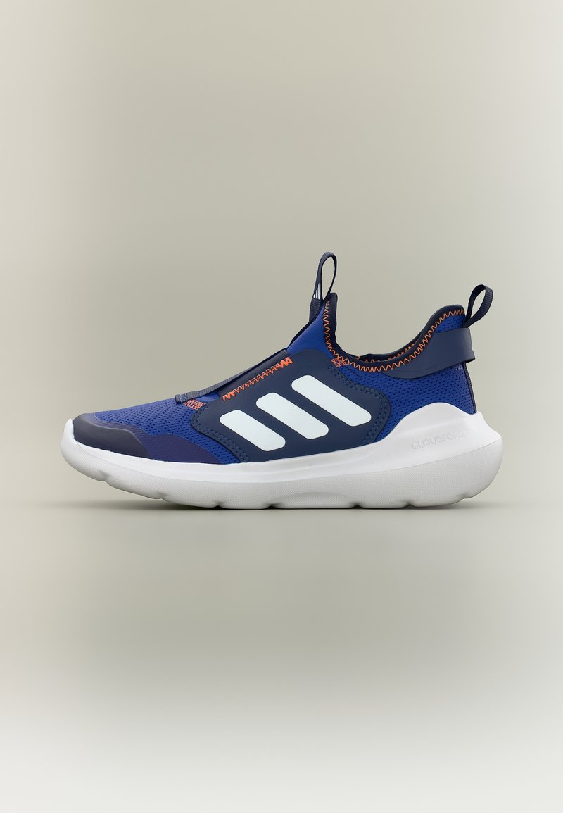 Niebiesko-granatowy tenisówka na wsuwkę z białą podeszwą i trzema białymi paskami po bokach, ozdobiona pomarańczowym przeszyciem oraz pętelkami do ściągania na pięcie i języku.