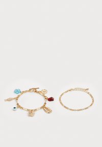 Gouden armbanden: de ene met bedels (vis, vlinder, hart, blauwe bloem) en de andere met een eenvoudig schakeldesign.