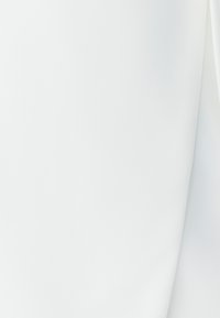 Jemná bílá látka s hladkým, mírně texturovaným povrchem; elegantně se skládá s lehkými záhyby a jemným leskem.