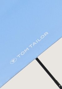 Lichtblauwe paraplu met een zwarte handgreep. Bevat het witte "TOM TAILOR" logo, heeft een gladde stoftextuur en gestikte randen voor extra duurzaamheid.