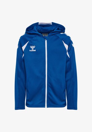 Blauwe Hummel sportjas met ritssluiting, witte accenten, een capuchon en een logo op de borst, afgebeeld op een witte achtergrond.