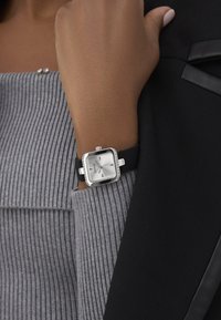 Must mustriba mustri, millebe pehmed ja hõbedase ruudukujulise näo, millel on teemantiga ääris, ja hall ribide muster. Minimalistlik disain ja sile tekstuur.