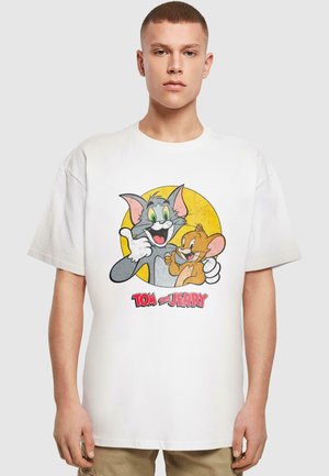 Hvid bomulds t-shirt med et grafisk motiv af Tom og Jerry i livlige farver, rund gul baggrund og med fed skrift "TOM og JERRY" nedenfor.