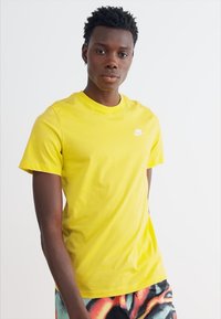 Nike Sportswear CLUB TEE - Navadna majica - yellow