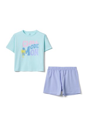 Hellblaues T-Shirt mit kurzen Ärmeln mit der Aufschrift „Chill Mode On“ und einer gelben Palme als Grafik, kombiniert mit hellvioletten Shorts mit elastischem Bund.