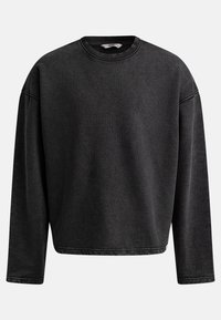 Sweatshirt noir surdimensionné avec des manches longues, un col rond et une texture côtelée. Présente des coutures renforcées aux poignets et à l'ourlet.