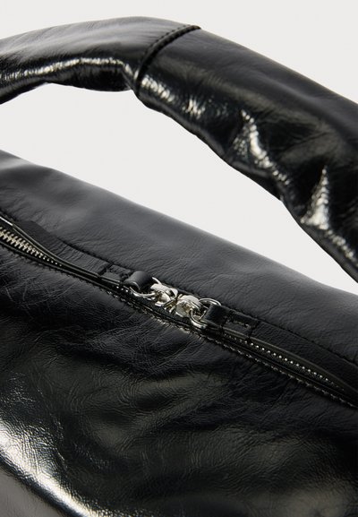 Bolsa de pele preta com uma textura brilhante, apresentando um fecho de zip e uma pega almofadada. A bolsa tem uma forma elegante e arredondada.